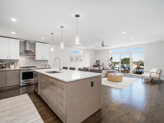 2707 W Belmont Ave Unit 4W, Chicago, IL 60618 - kitchen with wall chimney exhaust hood, appliances with stainless steel finishes, modern cabinets, dark wood-style floors, and recessed lighting