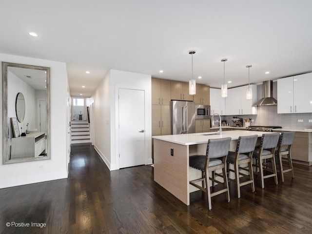 2707 W Belmont Ave Unit 4W, Chicago, IL 60618 - kitchen featuring appliances with stainless steel finishes, wall chimney exhaust hood, a kitchen breakfast bar, light countertops, and modern cabinets