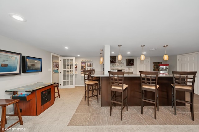 2741 Acacia Ter, Buffalo Grove, IL 60089 - kitchen featuring recessed lighting, light countertops, a breakfast bar, light colored carpet, and hanging light fixtures