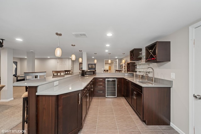 2741 Acacia Ter, Buffalo Grove, IL 60089 - kitchen with beverage cooler, stainless steel microwave, a breakfast bar area, dark brown cabinets, and recessed lighting