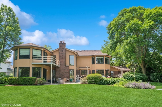 2741 Acacia Ter, Buffalo Grove, IL 60089 - back of property with a balcony, a chimney, a lawn, and a patio area