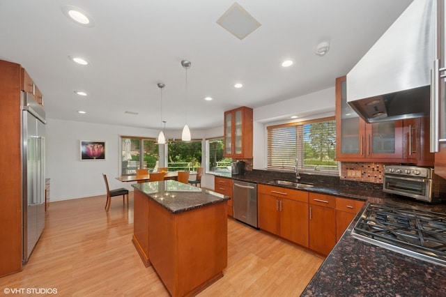 2741 Acacia Ter, Buffalo Grove, IL 60089 - kitchen featuring wall chimney range hood, stainless steel appliances, a center island, light wood-type flooring, and healthy amount of natural light