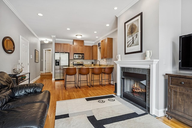 4660 N Winthrop Ave Unit 1N, Chicago, IL 60640 - living area with crown molding, light wood-style flooring, recessed lighting, and a tiled fireplace