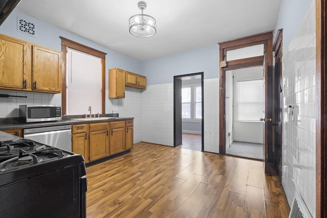 2219 S 60th Ct, Cicero, IL 60804 - kitchen with appliances with stainless steel finishes, dark countertops, wood finished floors, pendant lighting, and tasteful backsplash