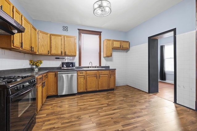 2219 S 60th Ct, Cicero, IL 60804 - kitchen with appliances with stainless steel finishes, ventilation hood, dark countertops, dark wood-style floors, and brown cabinetry