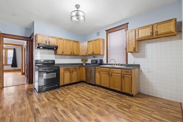 2219 S 60th Ct, Cicero, IL 60804 - kitchen featuring stainless steel appliances, under cabinet range hood, dark countertops, dark wood finished floors, and decorative backsplash