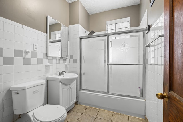 2219 S 60th Ct, Cicero, IL 60804 - bathroom featuring vanity, tile walls, enclosed tub / shower combo, tile patterned floors, and a textured ceiling