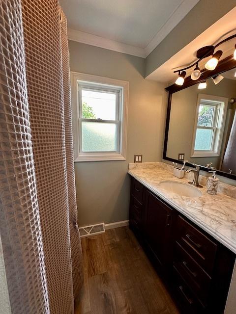 1700 Sunset Dr, Mendota, IL 61342 - full bath with vanity, wood finished floors, crown molding, and curtained shower