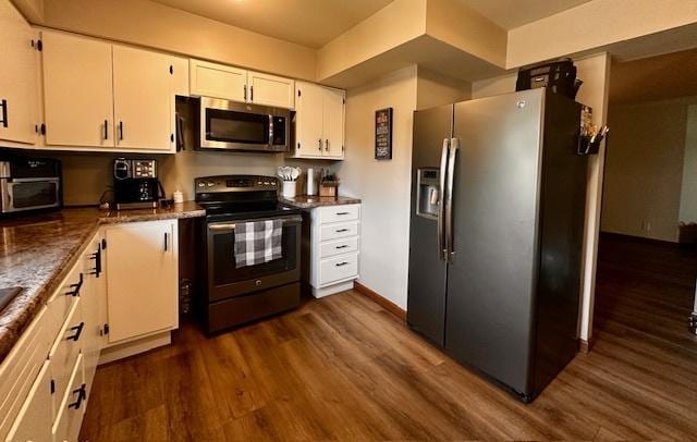1700 Sunset Dr, Mendota, IL 61342 - kitchen featuring appliances with stainless steel finishes, dark wood-type flooring, white cabinets, and dark stone countertops