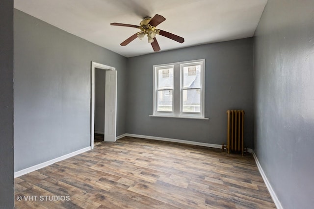 32 W 109th Pl, Chicago, IL 60628 - spare room featuring radiator heating unit, wood finished floors, and ceiling fan