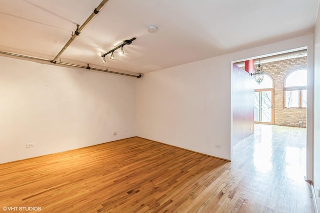 920 W Sheridan Rd Unit 305, Chicago, IL 60613 - spare room featuring wood finished floors, a chandelier, and brick wall