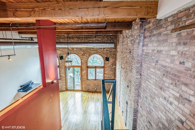 920 W Sheridan Rd Unit 305, Chicago, IL 60613 - hallway with brick wall, wood finished floors, and a wooden ceiling with exposed beams
