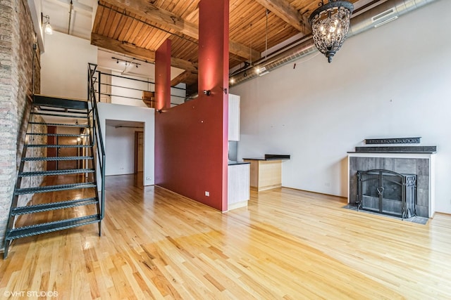 920 W Sheridan Rd Unit 305, Chicago, IL 60613 - unfurnished living room with wood finished floors, a wood ceiling with exposed beams, stairway, and a towering ceiling