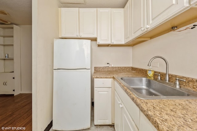 2728 N Hampden Ct Unit 103, Chicago, IL 60614 - kitchen with freestanding refrigerator, light countertops, white cabinets, wood finished floors, and a textured ceiling