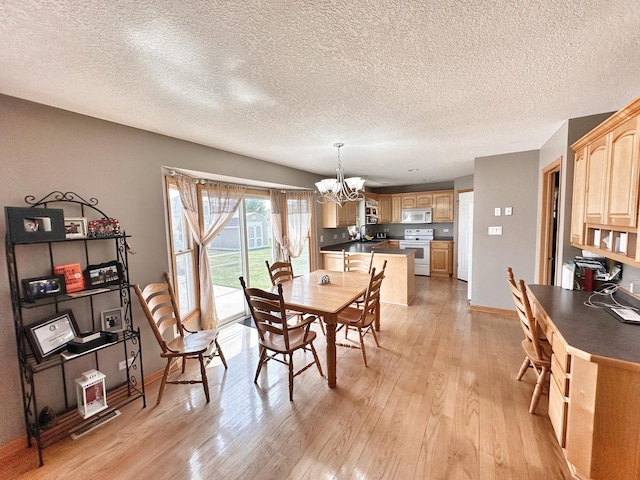 597 Barry Turn, Manteno, IL 60950 - dining room featuring a chandelier, light wood-style flooring, and a textured ceiling