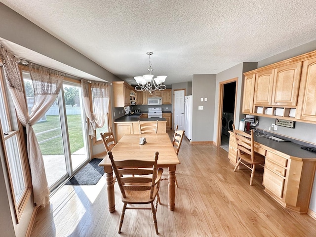 597 Barry Turn, Manteno, IL 60950 - dining area with a chandelier, light wood finished floors, built in study area, a textured ceiling, and washer / clothes dryer
