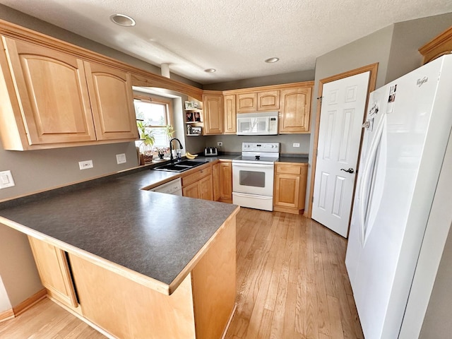 597 Barry Turn, Manteno, IL 60950 - kitchen with white appliances, a peninsula, dark countertops, light wood-type flooring, and light brown cabinetry
