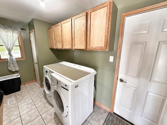597 Barry Turn, Manteno, IL 60950 - washroom with washing machine and dryer, cabinet space, light tile patterned floors, and a textured ceiling