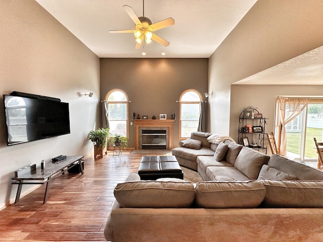 597 Barry Turn, Manteno, IL 60950 - living room featuring ceiling fan, wood finished floors, a fireplace with flush hearth, a towering ceiling, and recessed lighting