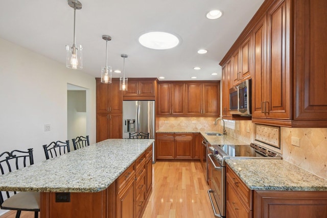 5085 Dukesberry Ln, Hoffman Estates, IL 60010 - kitchen featuring stainless steel appliances, a kitchen bar, brown cabinets, light wood-style flooring, and recessed lighting