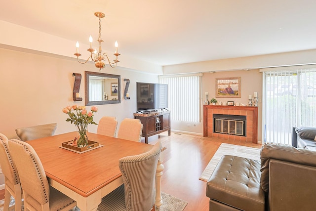 377 Grissom Ct, Hoffman Estates, IL 60169 - dining space with wood finished floors, a chandelier, and a tiled fireplace