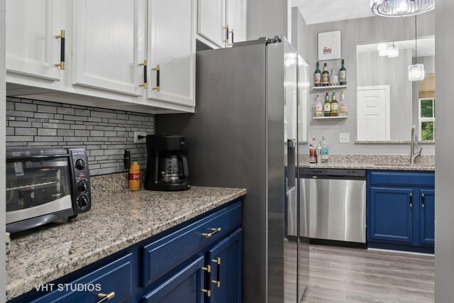 2582 Golf Ridge Cir, Naperville, IL 60563 - kitchen with stainless steel dishwasher, blue cabinets, white cabinets, decorative backsplash, and light stone counters