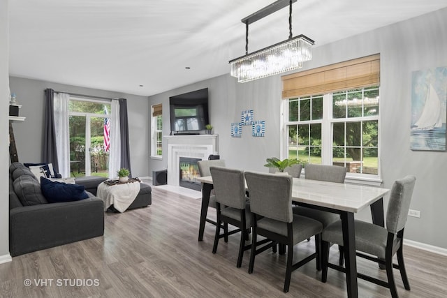 2582 Golf Ridge Cir, Naperville, IL 60563 - dining room featuring a glass covered fireplace, wood finished floors, and a chandelier