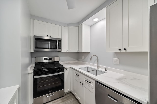 8232 Niles Center Rd Unit 101, Skokie, IL 60077 - kitchen featuring stainless steel appliances, white cabinetry, light stone countertops, light wood-style flooring, and recessed lighting