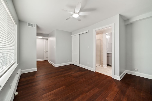 8232 Niles Center Rd Unit 101, Skokie, IL 60077 - unfurnished bedroom featuring wood finished floors, a baseboard radiator, ceiling fan, and connected bathroom