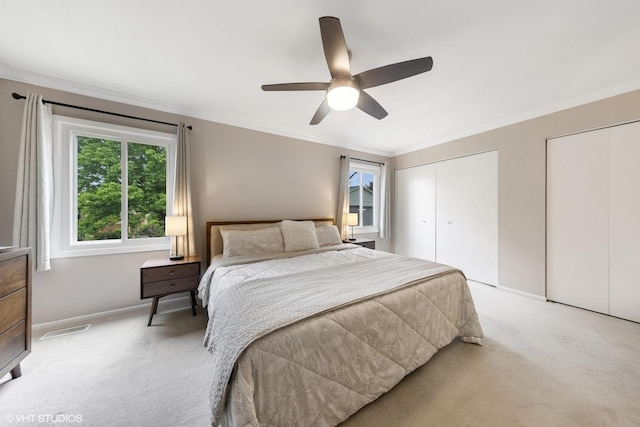 647 Farnham Ln, Wheaton, IL 60189 - bedroom with light carpet, multiple closets, ornamental molding, and a ceiling fan
