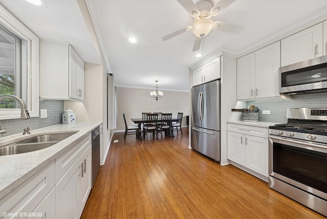 647 Farnham Ln, Wheaton, IL 60189 - kitchen featuring appliances with stainless steel finishes, white cabinets, tasteful backsplash, crown molding, and light wood-style flooring