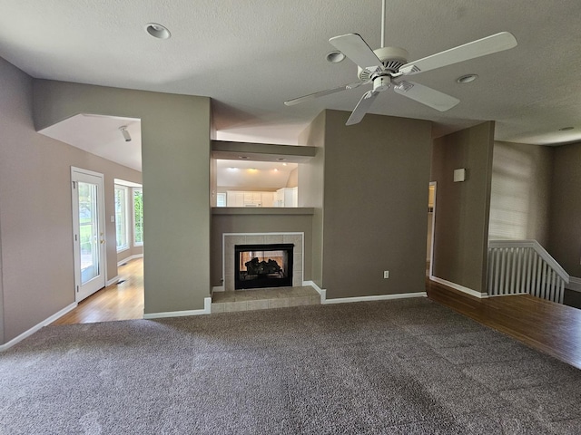210 Barrington Dr, Bourbonnais, IL 60914 - unfurnished living room with carpet flooring, a ceiling fan, a tile fireplace, and a textured ceiling