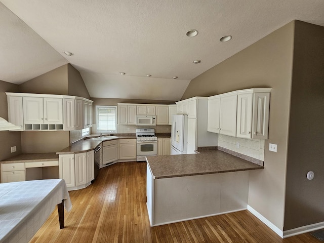 210 Barrington Dr, Bourbonnais, IL 60914 - kitchen with white appliances, a peninsula, wood-type flooring, decorative backsplash, and lofted ceiling