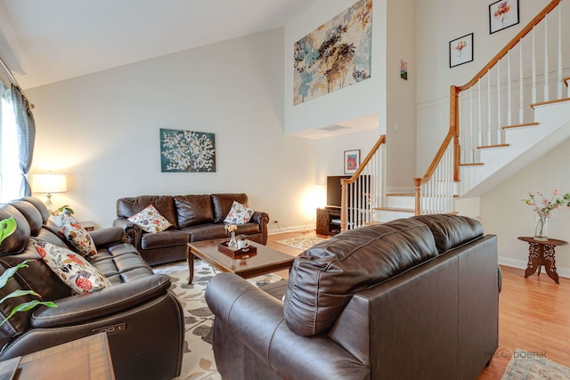 552 Arbor Gate Ln, Buffalo Grove, IL 60089 - living room featuring stairs, a high ceiling, and light wood-style flooring