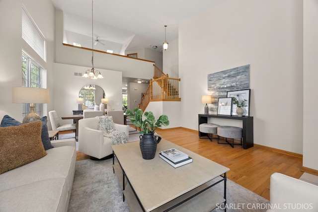 1962 Highbury Ln, Aurora, IL 60502 - living room featuring wood finished floors, stairway, high vaulted ceiling, a chandelier, and a ceiling fan