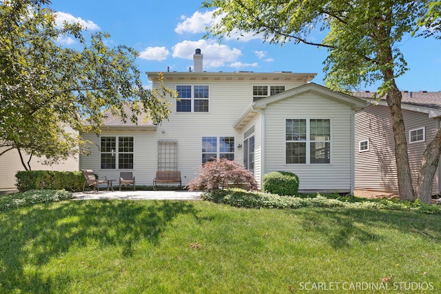 1962 Highbury Ln, Aurora, IL 60502 - back of property featuring a chimney, a lawn, and a patio