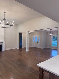 25136 Thornberry Dr Unit 25136, Plainfield, IL 60544 - unfurnished living room featuring a chandelier, dark wood-style floors, and a fireplace