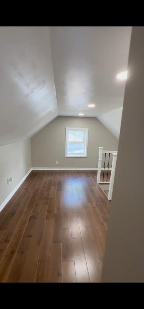 additional living space featuring lofted ceiling and wood finished floors