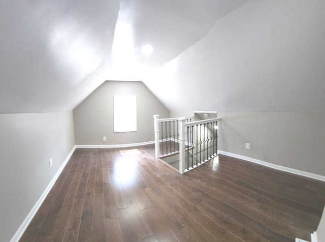 additional living space with wood-type flooring and vaulted ceiling