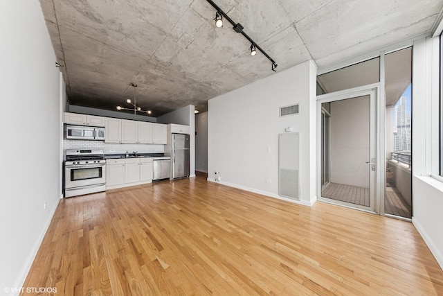 1720 S Michigan Ave Unit 2106, Chicago, IL 60616 - unfurnished living room featuring track lighting, light wood-style floors, and a heating unit