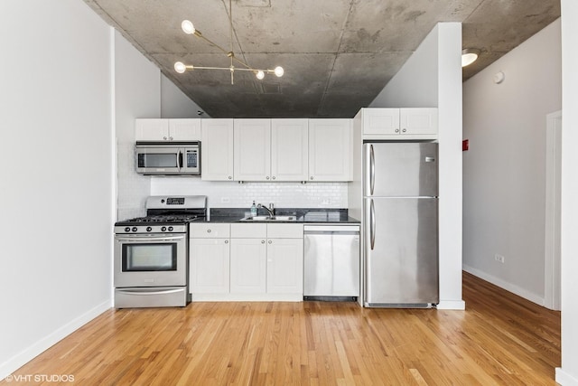 1720 S Michigan Ave Unit 2106, Chicago, IL 60616 - kitchen featuring stainless steel appliances, light wood finished floors, backsplash, white cabinetry, and dark countertops