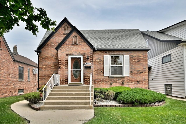 7238 W Clarence Ave, Chicago, IL 60631 - tudor home featuring brick siding, a shingled roof, and a front yard