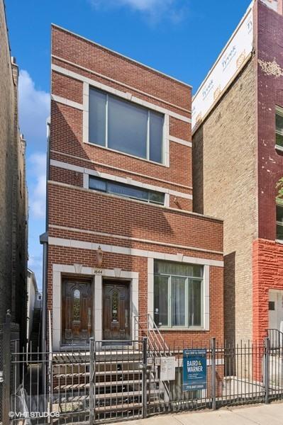 1644 W Lemoyne St Unit 1, Chicago, IL 60622 - view of front of house featuring brick siding and a fenced front yard