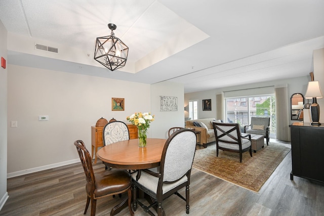570 Crescent Blvd Unit 307, Glen Ellyn, IL 60137 - dining area featuring wood finished floors, a chandelier, and a raised ceiling