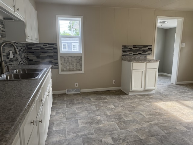 401 E 1st St, Oglesby, IL 61348 - kitchen with tasteful backsplash, light stone finish floors, and white cabinetry