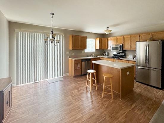 645 Tally St, Earlville, IL 60518 - kitchen with appliances with stainless steel finishes, wood finished floors, a chandelier, a center island, and light countertops