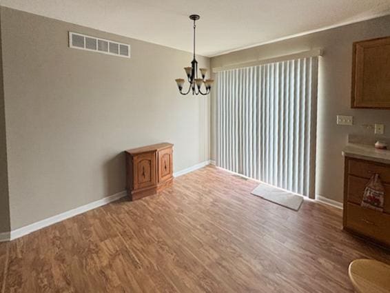 645 Tally St, Earlville, IL 60518 - unfurnished dining area with light wood-style flooring and a chandelier