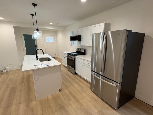 8317 S Constance Ave, Chicago, IL 60617 - kitchen featuring stainless steel appliances, white cabinetry, light wood-type flooring, recessed lighting, and light countertops
