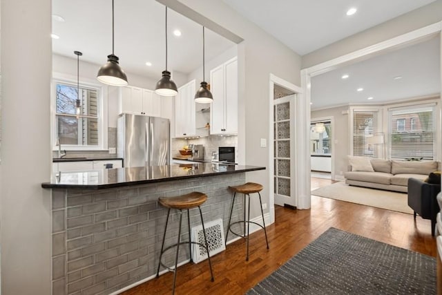 3739 W Palmer St, Chicago, IL 60647 - kitchen with freestanding refrigerator, dark countertops, backsplash, white cabinets, and recessed lighting