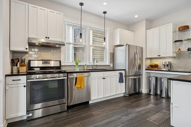 3739 W Palmer St, Chicago, IL 60647 - kitchen with stainless steel appliances, under cabinet range hood, open shelves, dark countertops, and dark wood-style flooring